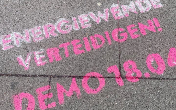 Sprühfarbe auf Gehweg. Aufruf zur Demo Energiewende verteidigen